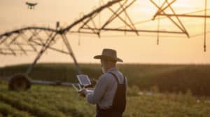 a man standing in a farm using technology to help farm